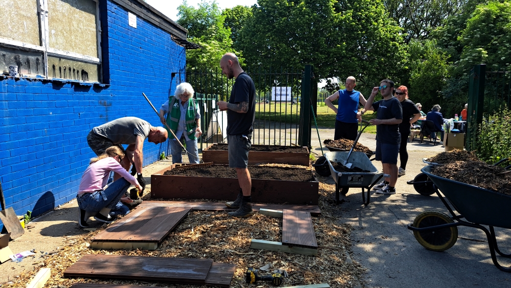 A group of volunteers working outside on building wooden planters